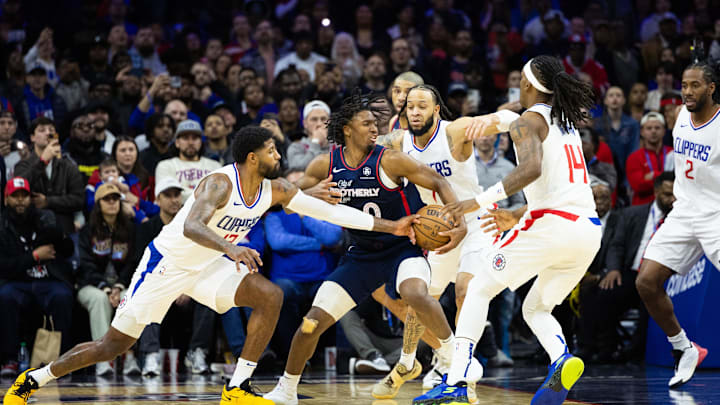Mar 27, 2024; Philadelphia, Pennsylvania, USA; LA Clippers forward Paul George (13) and guard Terance Mann (14) defend against Philadelphia 76ers guard Tyrese Maxey (0) during the fourth quarter at Wells Fargo Center. Mandatory Credit: Bill Streicher-Imagn Images