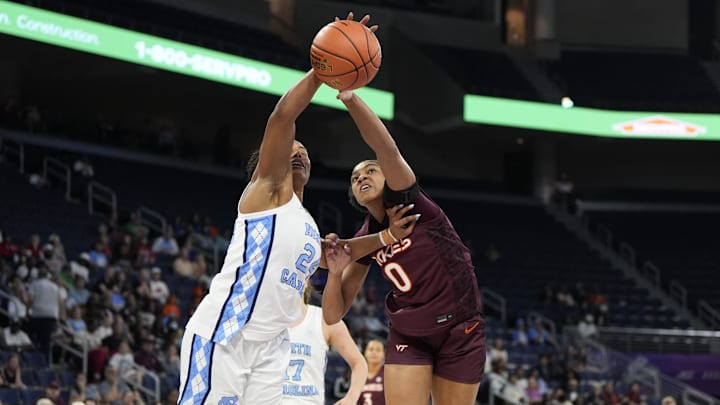 Mar 6, 2026; Duluth, GA, USA; North Carolina Tar Heels guard Indya Nivar (24) and Virginia Tech Hokies forward Kilah Freelon (0) fight for the ball during the first half at Gas South Arena.