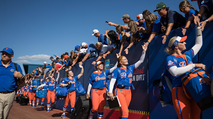 May 30, 2025; Oklahoma City, OK, USA;  Florida Gators pitcher Katelynn Oxley (39) and infielder Mia Williams (11) along with their teammates, enter the stadium and greet the fans before their game against the Tennessee Lady Volunteers in the NCAA Softball Women's College World Series at Devon Park. Mandatory Credit: Brett Rojo-Imagn Images