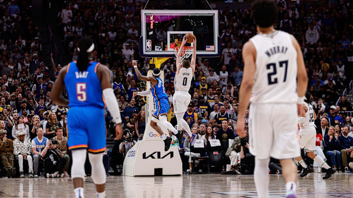 May 15, 2025; Denver, Colorado, USA; Denver Nuggets guard Christian Braun (0) dunks the ball against Oklahoma City Thunder guard Shai Gilgeous-Alexander (2) on a breakaway as guard Luguentz Dort (5) and guard Jamal Murray (27) look on in the first quarter during game six of the second round for the 2025 NBA Playoffs at Ball Arena. Mandatory Credit: Isaiah J. Downing-Imagn Images