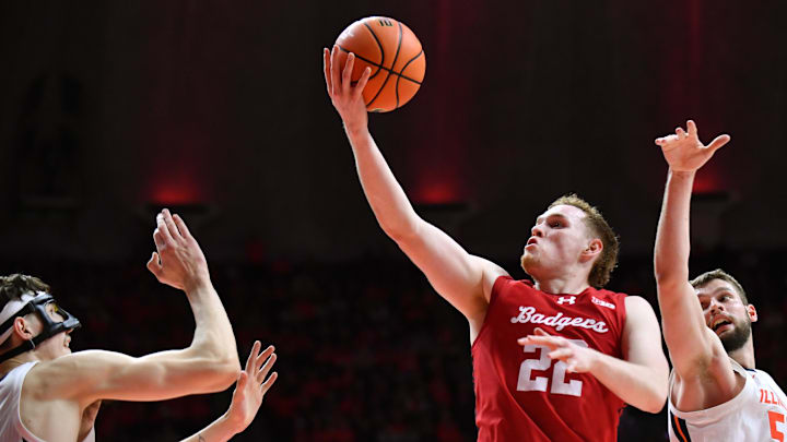 Feb 10, 2026; Champaign, Illinois, USA;  Wisconsin Badgers forward Austin Rapp (22) drives to the basket as Illinois Fighting Illini forward Zvonimir Ivisic (44) and Illinois Fighting Illini center Tomislav Ivisic (52) defend during the second half at State Farm Center. Mandatory Credit: Ron Johnson-Imagn Images