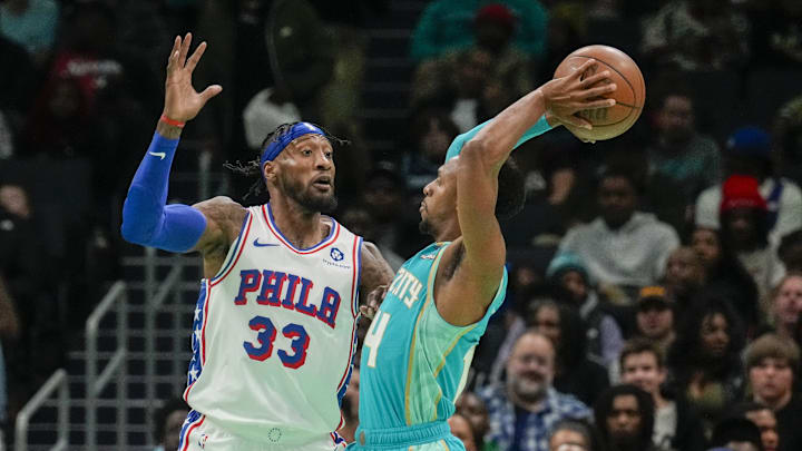 Dec 16, 2023; Charlotte, North Carolina, USA; Charlotte Hornets guard Ish Smith (14) attempts to pass the ball against Philadelphia 76ers forward Robert Covington (33) during the second quarter at Spectrum Center. Mandatory Credit: Jim Dedmon-Imagn Images