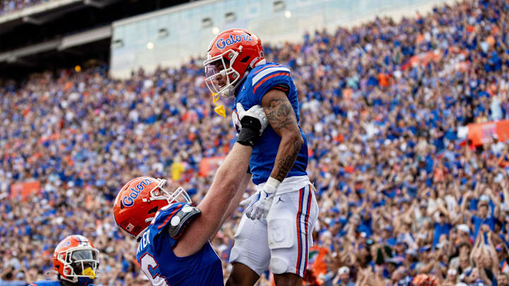 Florida Gators offensive lineman Jake Slaughter (66) holds up Florida Gators wide receiver Eugene Wilson III (3) after a touchdown during the second half at Steve Spurrier Field at Ben Hill Griffin Stadium in Gainesville, FL on Saturday, October 7, 2023. [Matt Pendleton/Gainesville Sun]