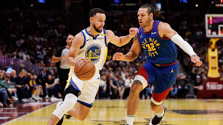 Dec 3, 2024; Denver, Colorado, USA; Golden State Warriors guard Stephen Curry (30) controls the ball as Denver Nuggets forward Aaron Gordon (32) guards in the second quarter at Ball Arena. Mandatory Credit: Isaiah J. Downing-Imagn Images