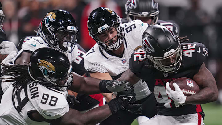 Aug 23, 2024; Atlanta, Georgia, USA; Atlanta Falcons running back Spencer Brown (42) is tackled by Jacksonville Jaguars defensive tackle Jordan Jefferson (98) and defensive end Joe Gaziano (97) during the second half at Mercedes-Benz Stadium. Mandatory Credit: Dale Zanine-Imagn Images