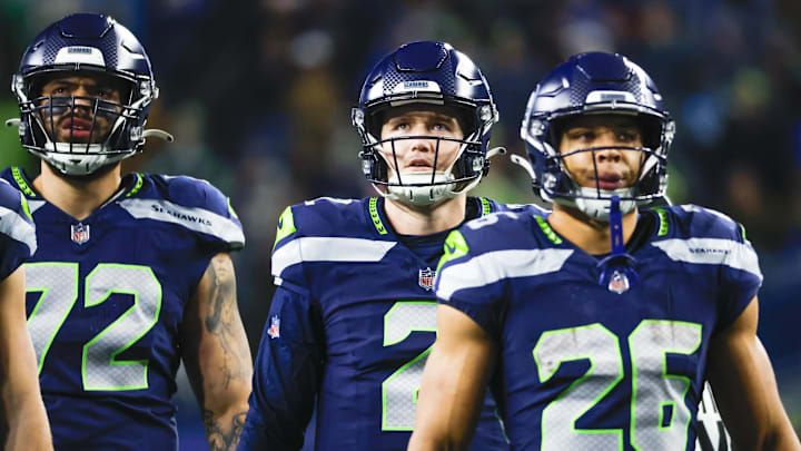 Dec 18, 2023; Seattle, Washington, USA; Seattle Seahawks quarterback Drew Lock (2), offensive tackle Abraham Lucas (72) and running back Zach Charbonnet (26) watch a replay of an intentional grounding penalty   against Lock during the second quarter against the Philadelphia Eagles at Lumen Field. Mandatory Credit: Joe Nicholson-Imagn Images