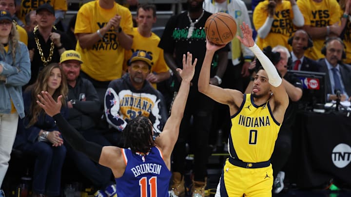 May 27, 2025; Indianapolis, Indiana, USA; Indiana Pacers guard Tyrese Haliburton (0) shoots a three point basket over New York Knicks guard Jalen Brunson (11) during the fourth quarter of game four of the eastern conference finals for the 2025 NBA Playoffs at Gainbridge Fieldhouse. Mandatory Credit: Trevor Ruszkowski-Imagn Images