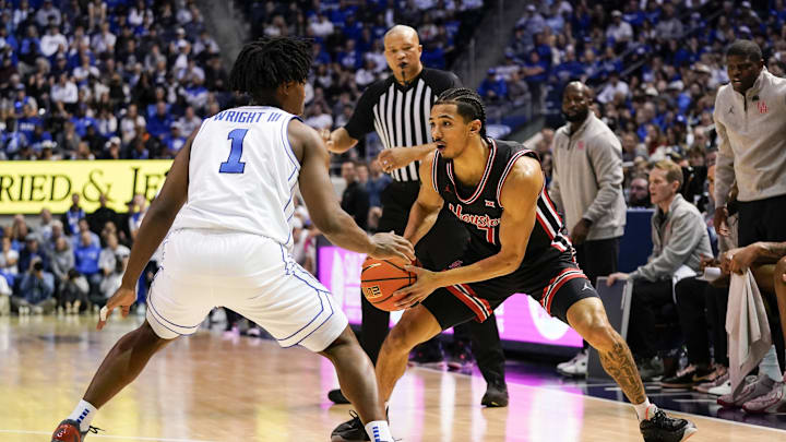 Feb 7, 2026; Provo, Utah, USA; Houston Cougars guard Milos Uzan (7) controls the ball while being defended by BYU Cougars guard Robert Wright III (1) during the second half at Marriott Center. Mandatory Credit: Aaron Baker-Imagn Images