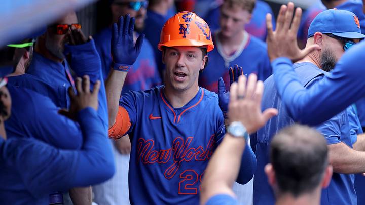 Mets first baseman Jared Young (29) celebrates his solo home run against the Cardinals with teammates in the dugout.