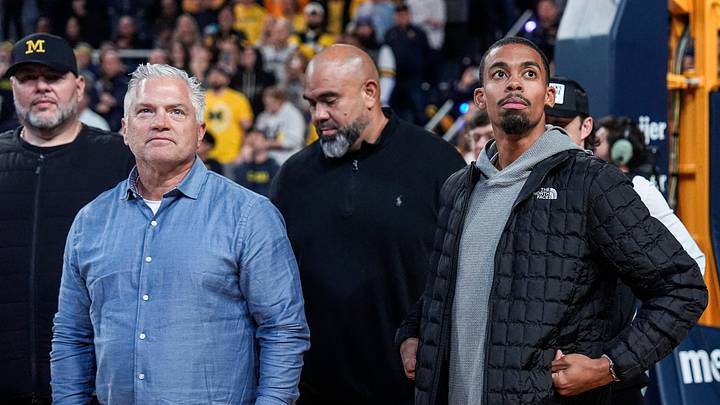 Michigan football tight ends coach Freddie Whittingham, left, and wide receivers coach Micah Simon looks on during football head coach Kyle Whittingham’s introduction during the first half between Michigan and USC at Crisler Center in Ann Arbor on Friday, Jan. 2, 2026. Michigan football tight ends coach Freddie Whittingham, left, and wide receivers coach Micah Simon looks on during football head coach Kyle Whittingham’s introduction during the first half between Michigan and USC at Crisler Center in Ann Arbor on Friday, Jan. 2, 2026.