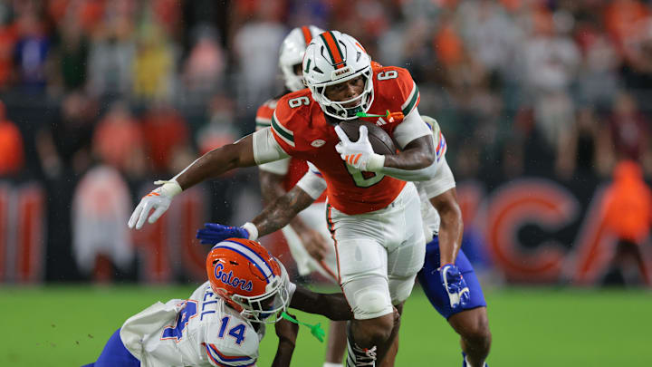 Sep 20, 2025; Miami Gardens, Florida, USA; Miami Hurricanes running back CharMar Brown (6) carries the football against Florida Gators defensive back Jordan Castell (14) during the first quarter at Hard Rock Stadium. Mandatory Credit: Sam Navarro-Imagn Images