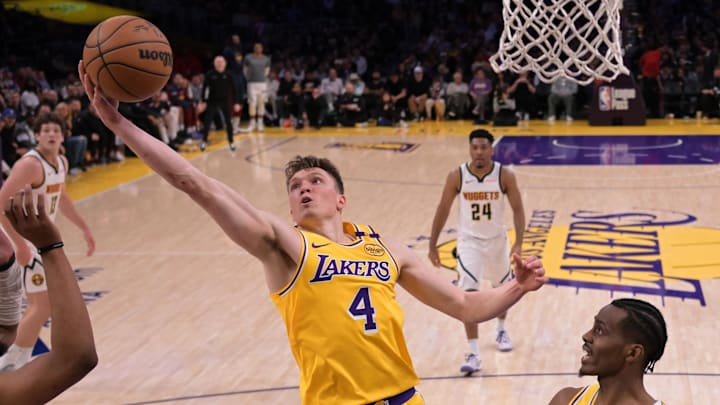 Mar 19, 2025; Los Angeles, California, USA; Denver Los Angeles Lakers guard Dalton Knecht (4) reaches for a rebound in the second half against the Denver Nuggets at Crypto.com Arena. Mandatory Credit: Jayne Kamin-Oncea-Imagn Images