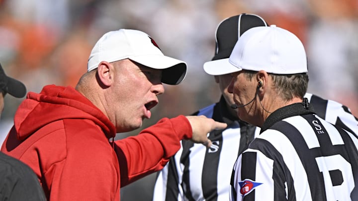 Louisville head coach Jeff Brohm argues with an official