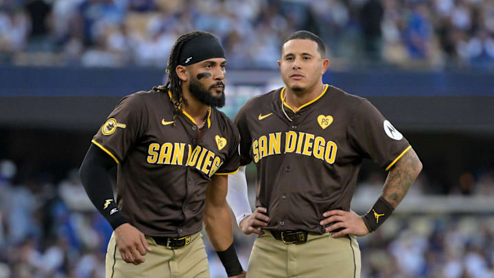 Oct 6, 2024; Los Angeles, California, USA; San Diego Padres outfielder Fernando Tatis Jr. (23) and third baseman Manny Machado (13) look on in the third inning against the Los Angeles Dodgers during game two of the NLDS for the 2024 MLB Playoffs at Dodger Stadium. Mandatory Credit: Jayne Kamin-Oncea-Imagn Images