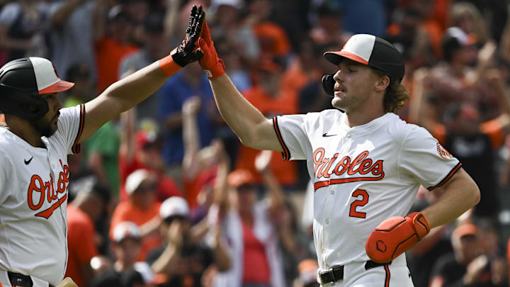 Baltimore Orioles shortstop Gunnar Henderson (2) high fives Baltimore Orioles outfielder Anthony Santander (25) after scoring during the fifth inning against the Detroit Tigers after at Oriole Park at Camden Yards in 2024.
