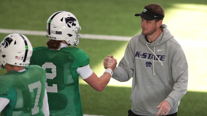 Kansas State head coach Collin Klein slaps hands with senior quarterback Avery Johnson (2) during practice on Tuesday, April 21, 2026.