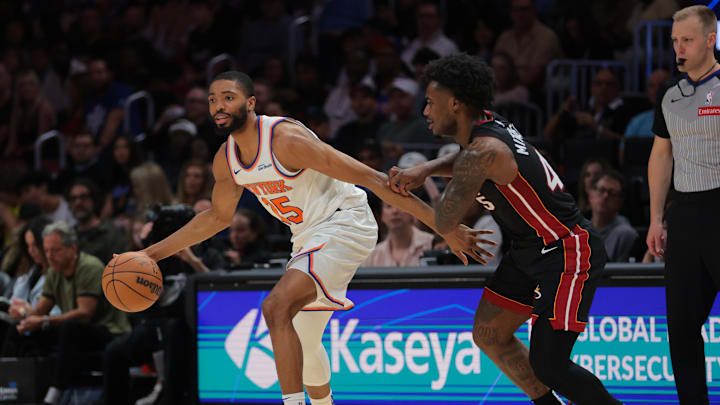 Mar 2, 2025; Miami, Florida, USA; New York Knicks forward Mikal Bridges (25) protects the basketball from Miami Heat guard Davion Mitchell (45) during the first quarter at Kaseya Center. Mandatory Credit: Sam Navarro-Imagn Images
