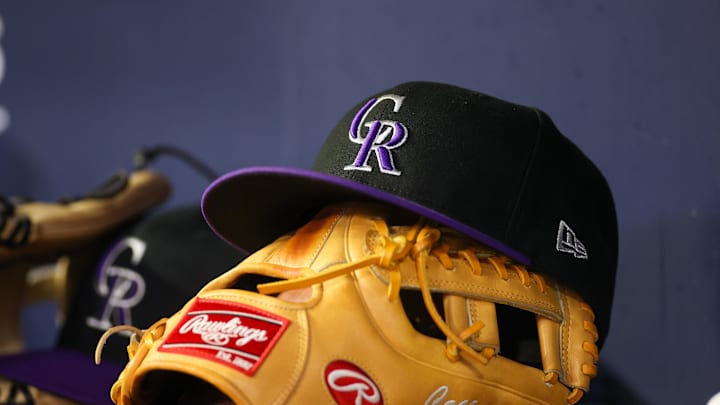 Jun 15, 2023; Atlanta, Georgia, USA; A detailed view of a Colorado Rockies hat and glove on the bench against the Atlanta Braves in the ninth inning at Truist Park. Mandatory Credit: Brett Davis-Imagn Images