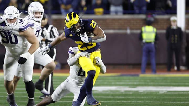 Nov 23, 2024; Ann Arbor, Michigan, USA;  Michigan Wolverines running back Jordan Marshall (23) is tackled by Northwestern Wildcats defensive back Devin Turner (8) in the second half at Michigan Stadium. Mandatory Credit: Rick Osentoski-Imagn Images