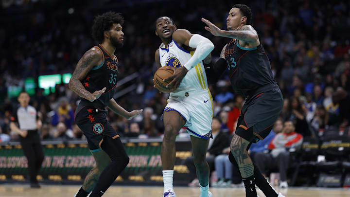 Feb 27, 2024; Washington, District of Columbia, USA; Golden State Warriors forward Jonathan Kuminga (00) drives to the basket as Washington Wizards forward Marvin Bagley III (35) and Wizards forward Kyle Kuzma (33) defend in the second half at Capital One Arena. Mandatory Credit: Geoff Burke-Imagn Images