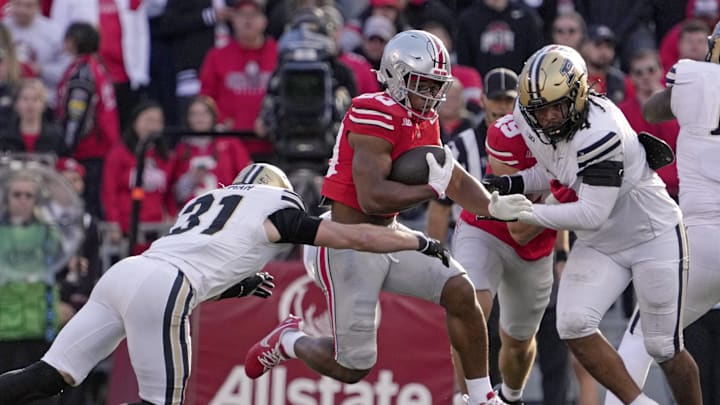 Nov 9, 2024; Columbus, Ohio, USA; Ohio State Buckeyes running back James Peoples (20) leaps away from Purdue Boilermakers defensive back Dillon Thieneman (31) during the second half  at Ohio Stadium. Mandatory Credit: Barbara Perenic/USA TODAY Network via Imagn Images