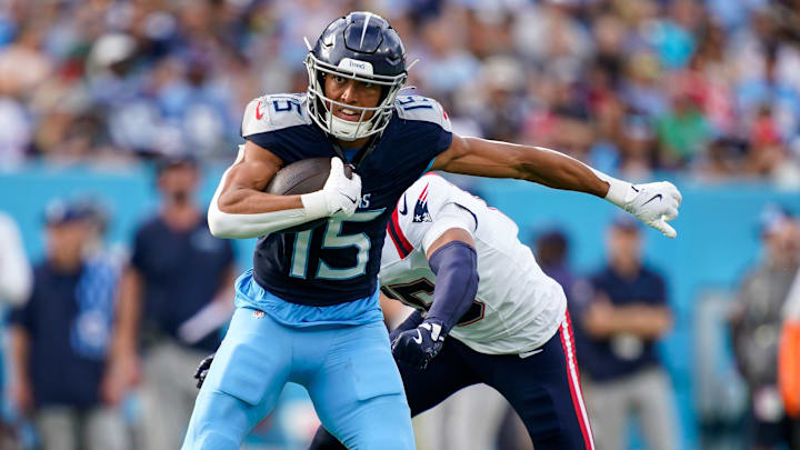 Tennessee Titans wide receiver Nick Westbrook-Ikhine (15) slips past New England Patriots safety Marte Mapu (15) for a first down during the third quarter at Nissan Stadium in Nashville, Tenn., Sunday, Nov. 3, 2024.