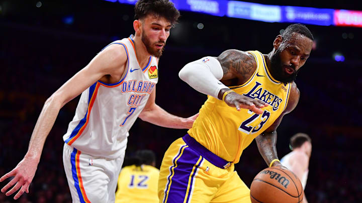 Mar 4, 2024; Los Angeles, California, USA; Los Angeles Lakers forward LeBron James (23) goes for the ball against Oklahoma City Thunder forward Chet Holmgren (7) during the second half at Crypto.com Arena. Mandatory Credit: Gary A. Vasquez-Imagn Images