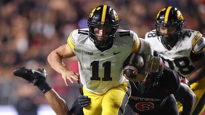 Sep 19, 2025; Piscataway, New Jersey, USA; Iowa Hawkeyes quarterback Mark Gronowski (11) fights for rushing yards as Rutgers Scarlet Knights linebacker Abram Wright (6) tackles during the second half at SHI Stadium. Mandatory Credit: Vincent Carchietta-Imagn Images
