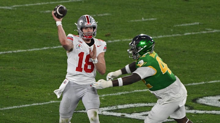 Jan 1, 2025; Pasadena, CA, USA; Ohio State Buckeyes quarterback Will Howard (18) passes against Oregon Ducks defensive lineman Aydin Breland (42) in during the fourth quarter at Rose Bowl Stadium. Mandatory Credit: Robert Hanashiro-Imagn Images