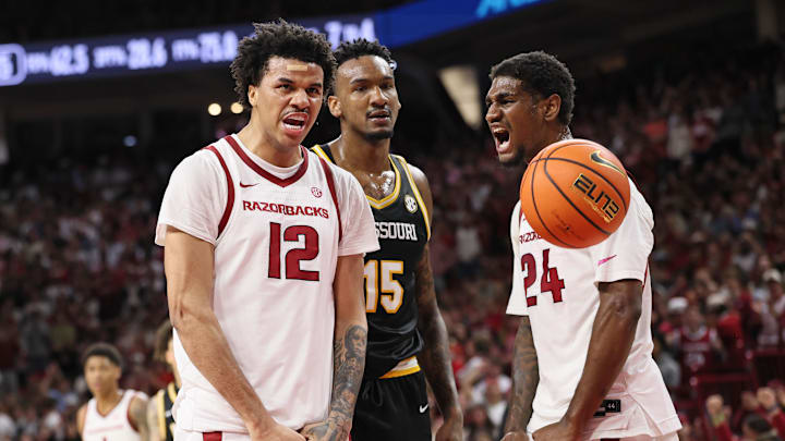 Feb 21, 2026; Fayetteville, Arkansas, USA; Arkansas Razorbacks forward Malique Ewin (12) and wing Billy Richmond III (24) react after a score as Missouri Tigers center Shawn Phillips Jr (15) looks on during the first half at Bud Walton Arena. Mandatory Credit: Nelson Chenault-Imagn Images