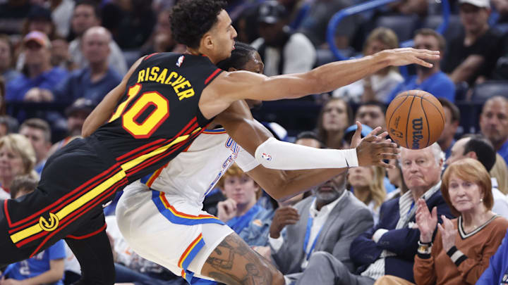 Oct 27, 2024; Oklahoma City, Oklahoma, USA; Atlanta Hawks forward Zaccharie Risacher (10) and Oklahoma City Thunder forward Jalen Williams (8) reach for a loose ball during the second quarter at Paycom Center. Mandatory Credit: Alonzo Adams-Imagn Images