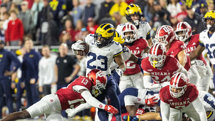Nov 9, 2024; Bloomington, Indiana, USA; Michigan Wolverines running back Jordan Marshall (23) runs with the ball while Indiana Hoosiers defensive back Cedarius Doss (13) defends in the second half at Memorial Stadium. Mandatory Credit: Trevor Ruszkowski-Imagn Images