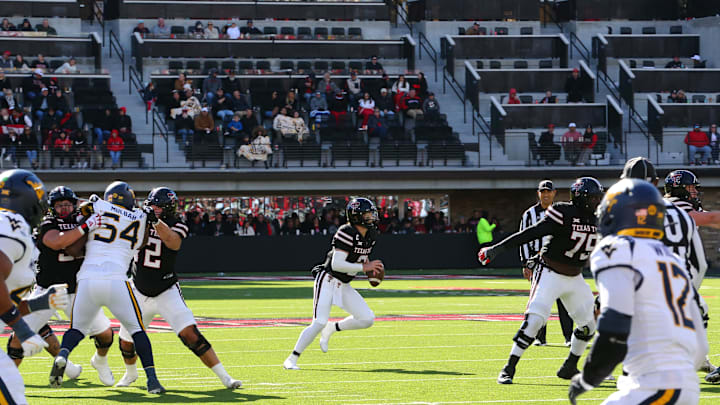 Nov 30, 2024; Lubbock, Texas, USA;  Texas Tech Red Raiders quarterback Behren Morton (2) scrambles against the West Virginia Mountaineers defensive in the first half at Jones AT&T Stadium and Cody Campbell Field. Mandatory Credit: Michael C. Johnson-Imagn Images