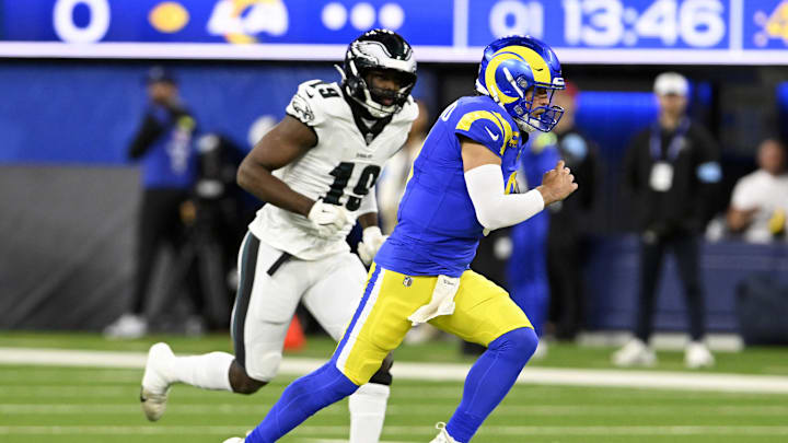 Nov 24, 2024; Inglewood, California, USA;  Los Angeles Rams quarterback Matthew Stafford (9) runs past Philadelphia Eagles linebacker Josh Sweat (19) on a scramble during the first half at SoFi Stadium. Mandatory Credit: Alex Gallardo-Imagn Images