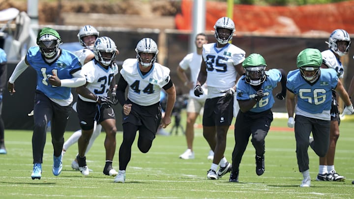 Jun 11, 2025; Charlotte, NC, USA; Carolina Panthers linebacker Nic Scourton (11), cornerback Mike Reid (35), long snapper JJ Jansen (44), tight end James Mitchell (85), safety Demani Richardson (36) and linebacker Christian Rozeboom (56) hustle to the ball during minicamp at Bank of America Stadium. Mandatory Credit: Jim Dedmon-Imagn Images