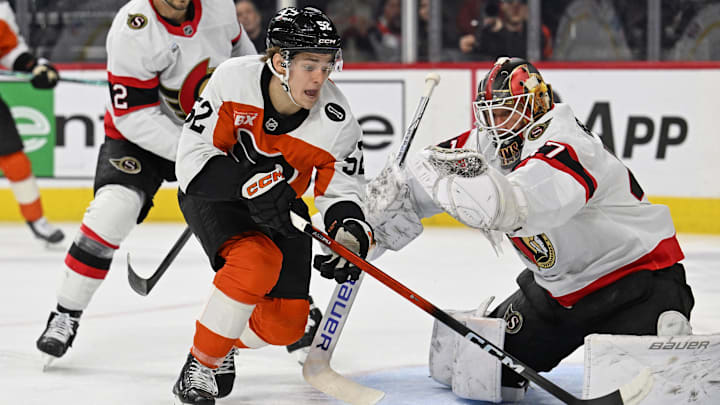 Feb 5, 2026; Philadelphia, Pennsylvania, USA; Philadelphia Flyers center Denver Barkey (52) reaches for the puck against Ottawa Senators goaltender James Reimer (47) during the first period at Xfinity Mobile Arena. Mandatory Credit: Eric Hartline-Imagn Images