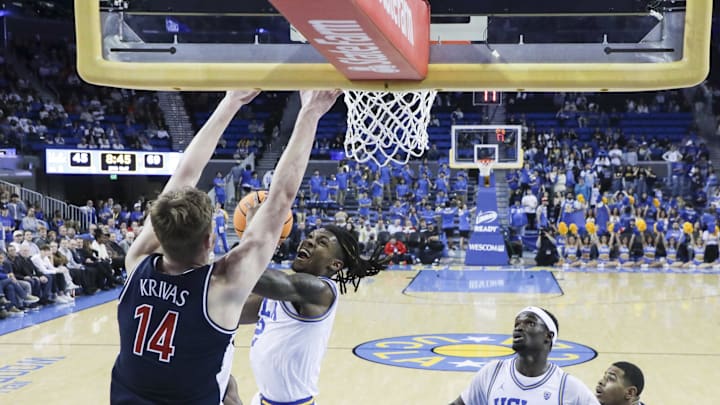 Mar 7, 2024; Los Angeles, California, USA; UCLA guard Sebastian Mack (12) attempts a layup as Arizona Wildcats center Motiejus Krivas (14) defends during the second half of a game at Pauley Pavilion presented by Wescom. Mandatory Credit: Yannick Peterhans-USA TODAY Sports