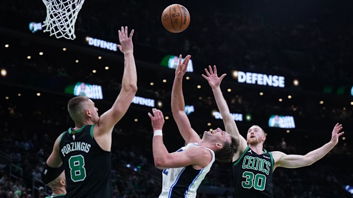 Apr 29, 2025; Boston, Massachusetts, USA; Boston Celtics forward Sam Hauser (30) and center Kristaps Porzingis (8) defend against Orlando Magic forward Franz Wagner (22) in the second quarter during game five of first round for the 2025 NBA Playoffs at TD Garden. Mandatory Credit: David Butler II-Imagn Images