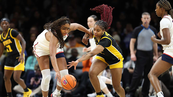Dec 20, 2025; Brooklyn, New York, USA; UConn Huskies forward Sarah Strong (21) and Iowa Hawkeyes guard Journey Houston (8) compete for the ball during the first half at Barclays Center. Mandatory Credit: Pamela Smith-Imagn Images