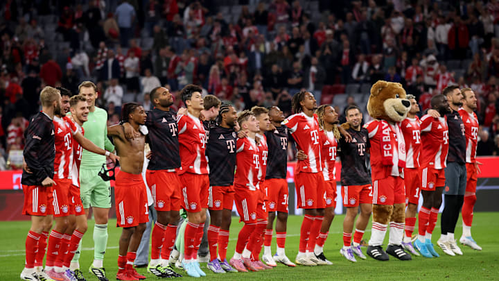Bayern Munich players celebrating with fans in front of home fans at Allianz Arena.