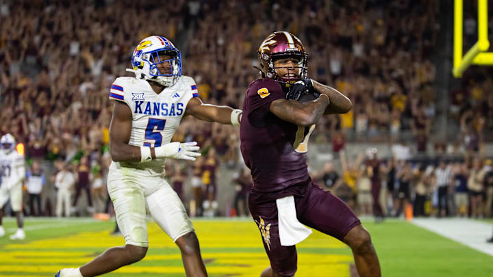 Oct 5, 2024; Tempe, Arizona, USA; Arizona State Sun Devils wide receiver Jordyn Tyson (0) scores a touchdown against Kansas Jayhawks safety O.J. Burroughs (5) in the fourth quarter at Mountain America Stadium. Mandatory Credit: Mark J. Rebilas-Imagn Images