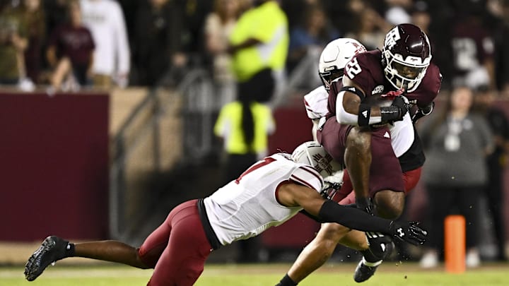 Nov 16, 2024; College Station, Texas, USA; New Mexico State Aggies cornerback Keonte Glinton (7) tackles Texas A&M Aggies running back EJ Smith (22) during the first quarter at Kyle Field. Mandatory Credit: Maria Lysaker-Imagn Images 