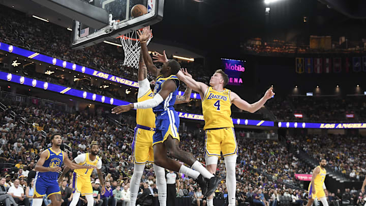 Oct 15, 2024; Las Vegas, Nevada, USA; Golden State Warriors forward Jonathan Kuminga (00) shoots against Los Angeles Lakers forward Anthony Davis (3) and guard Dalton Knecht (4) in the second quarter during a preseason game at T-Mobile Arena. Mandatory Credit: Candice Ward-Imagn Images