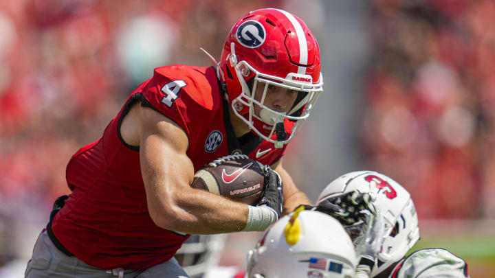 Sep 9, 2023; Athens, Georgia, USA; Georgia Bulldogs tight end Oscar Delp (4) jumps over tacklers against the Ball State Cardinals during the second half at Sanford Stadium. Mandatory Credit: Dale Zanine-USA TODAY Sports Sep 9, 2023; Athens, Georgia, USA; Georgia Bulldogs tight end Oscar Delp (4) jumps over tacklers against the Ball State Cardinals during the second half at Sanford Stadium. Mandatory Credit: Dale Zanine-USA TODAY Sports