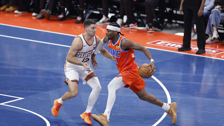 Dec 10, 2025; Oklahoma City, Oklahoma, USA; Oklahoma City Thunder guard Shai Gilgeous-Alexander (2) moves the ball past Phoenix Suns guard Collin Gillespie (12) during the third quarter at Paycom Center. Mandatory Credit: Alonzo Adams-Imagn Images