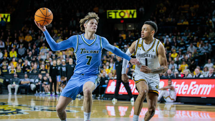 Feb 23, 2025; Wichita, Kansas, USA; Tulane Green Wave guard Rowan Brumbaugh (7) drives to the basket around Wichita State Shockers guard Xavier Bell (1) during the first half at Charles Koch Arena. Mandatory Credit: William Purnell-Imagn Images