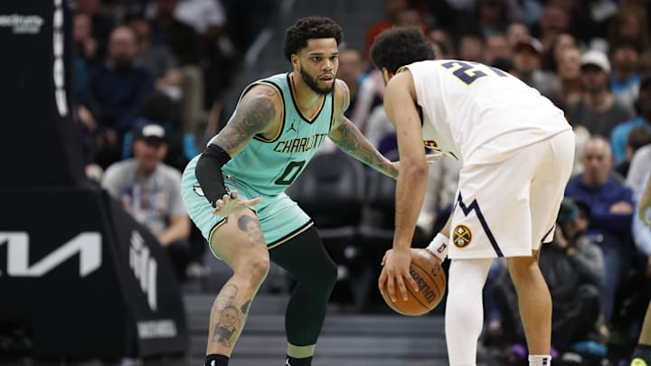 Feb 1, 2025; Charlotte, North Carolina, USA; Charlotte Hornets forward Miles Bridges (0) defends Denver Nuggets guard Jamal Murray (27) during the second half of play at Spectrum Center. Mandatory Credit: Brian Westerholt-Imagn Images