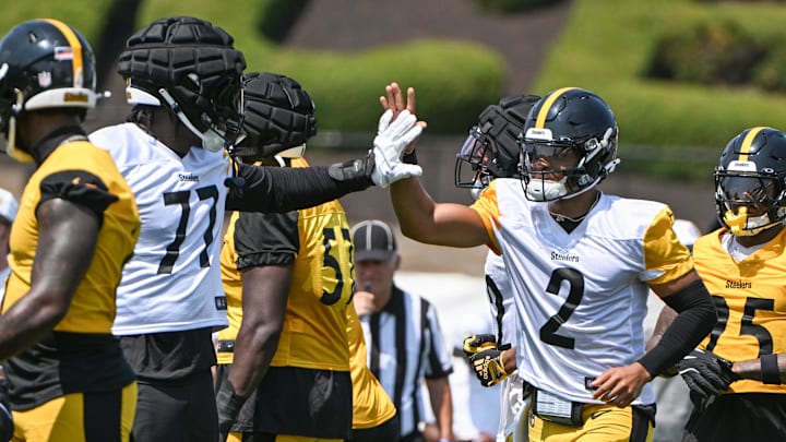 Jul 27, 2024; Latrobe, PA, USA; Pittsburgh Steelers quarterback Justin Fields celebrates with offensive tackle Broderick Jones (77) after scoring during training camp at Saint Vincent College. Mandatory Credit: Barry Reeger-USA TODAY Sports
