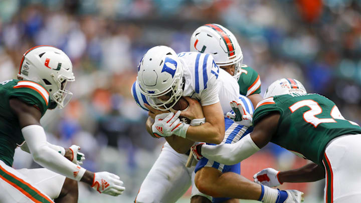 Oct 22, 2022; Miami Gardens, Florida, USA; Duke Blue Devils quarterback Riley Leonard (13) protects the football after a run during the second quarter against the Miami Hurricanes at Hard Rock Stadium. Mandatory Credit: Sam Navarro-Imagn Images