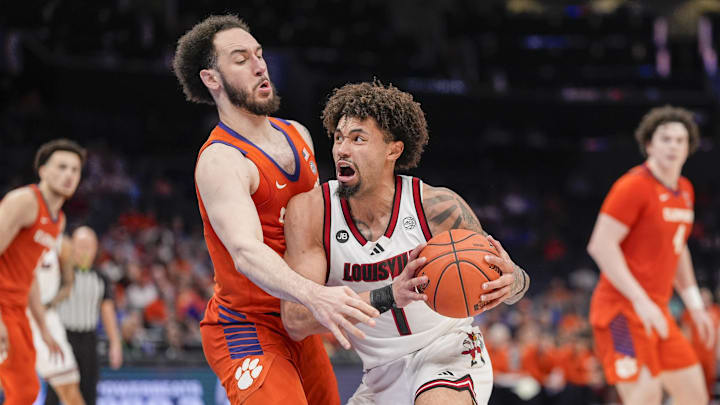 Mar 14, 2025; Charlotte, NC, USA;  Louisville Cardinals guard J'Vonne Hadley (1) makes contact with Clemson Tigers guard Jaeden Zackery (11) during the second half at Spectrum Center. Mandatory Credit: Jim Dedmon-Imagn Images
